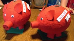 Zwei rote Sparschweine aus Pappmaschee